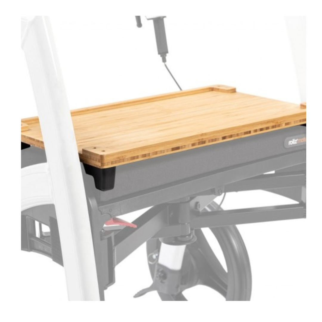 A wooden tray table with a white frame and black accents attaches to the wheelchair leg area, perfectly complementing the Rollz Motion Rollator Accessories for improved mobility.